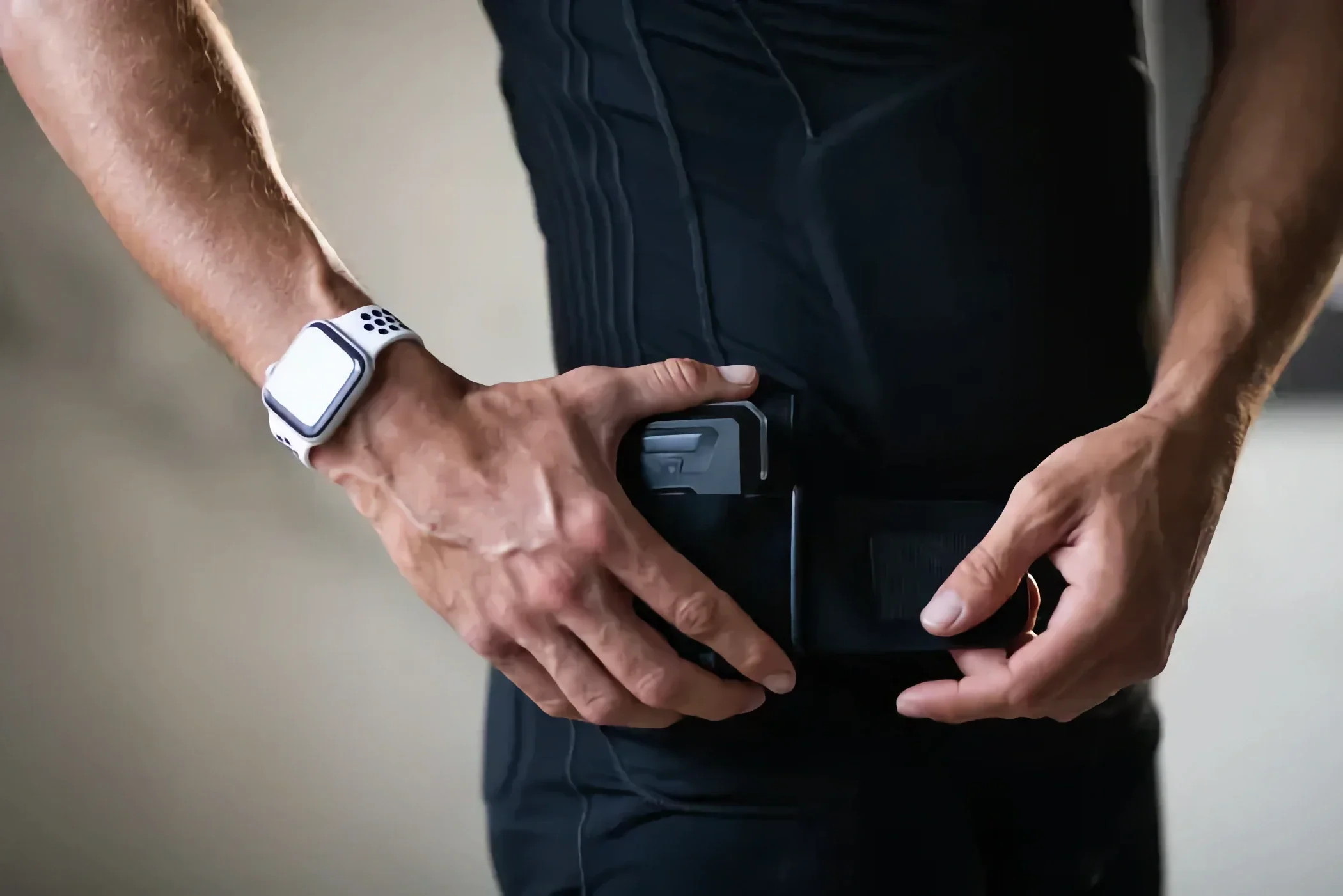 A person securing a fitness tracker around their waist