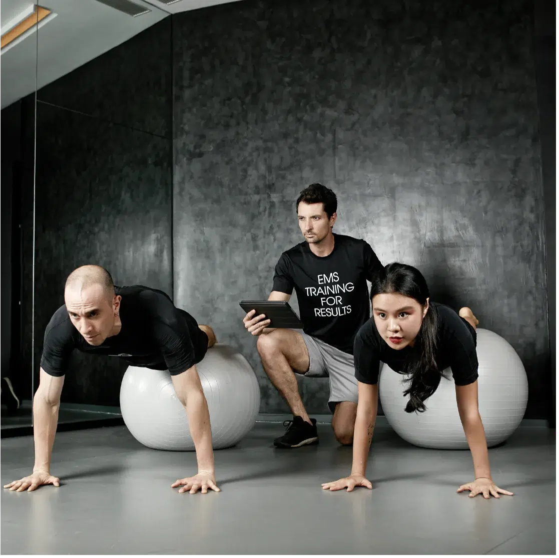 Three individuals engaged in a fitness session with EMS Tech
