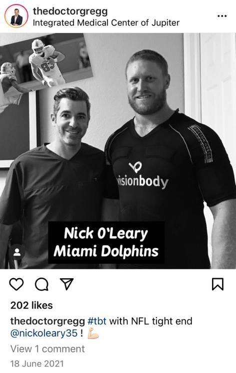 Two men posing for a photo, one in a black t-shirt with a logo